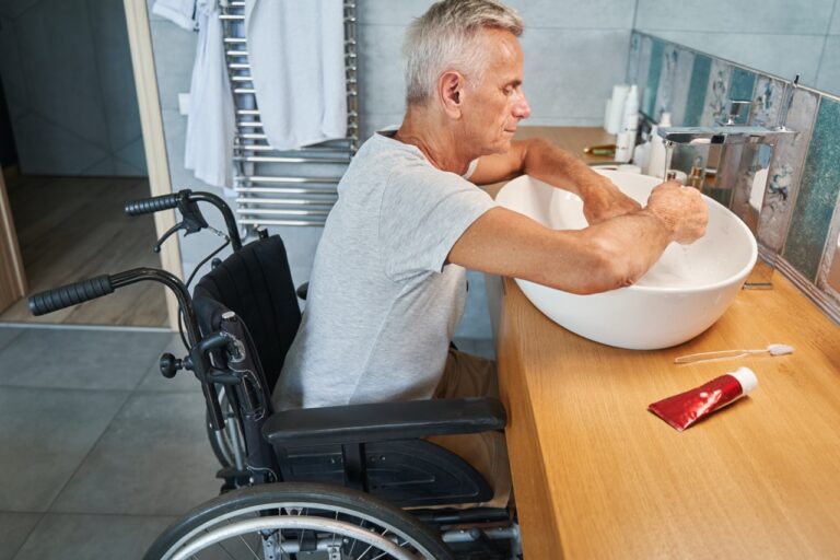 mature man in wheelchair washing his hands